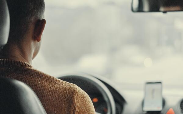 image of man driving a car viewed from back seat